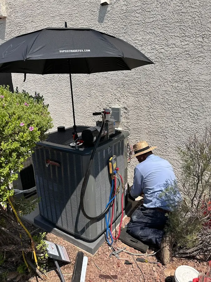 HVAC technician performing outdoor AC maintenance in Foxborough